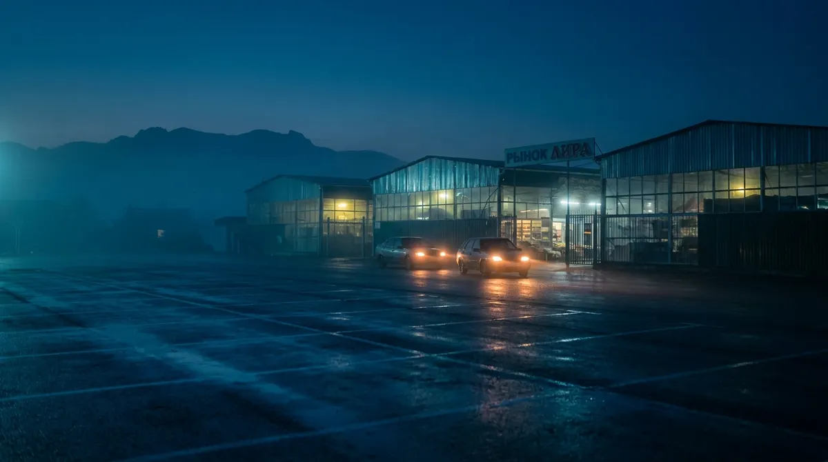 Подъезд к рынку «Лира» в Горячеводске на рассвете с машинами и торговыми модулями
